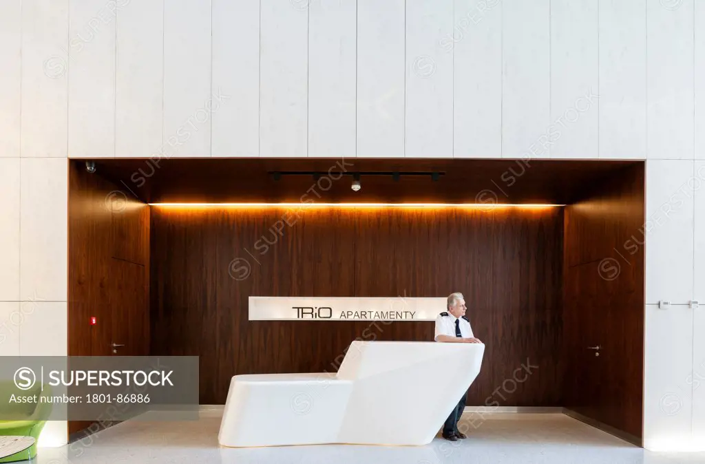 TRIO Apartment and Commercial building, Warsaw, Poland. Architect Jems Architekci, 2013. Porter posing at reception.