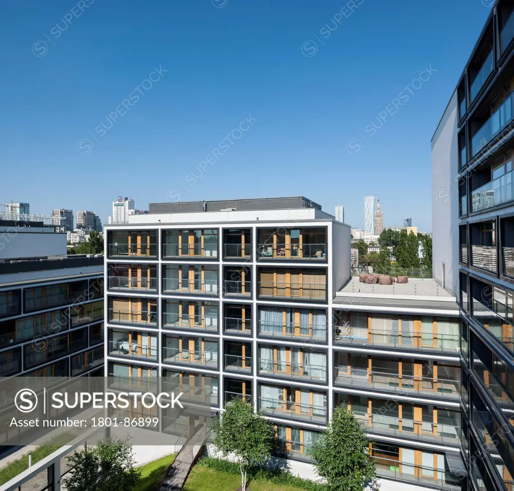 19th District Housing Complex, Warsaw, Poland. Architect Jems Architekci, 2013. Elevated view of apartments with Libeskin Tower in the background.