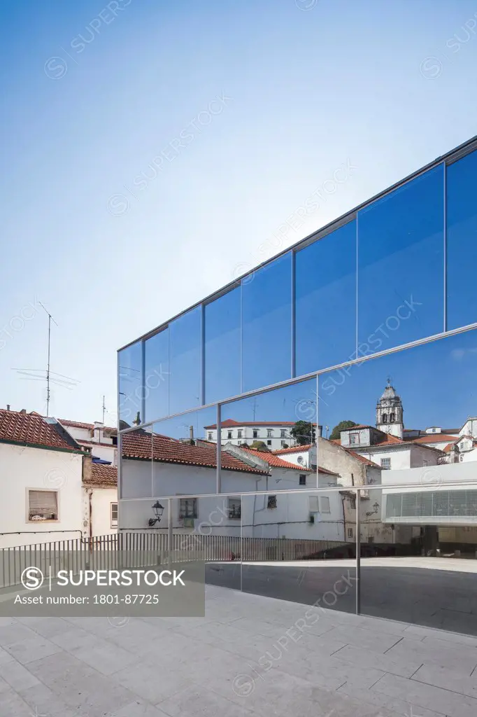 Edifício Praça Eça de Queiroz Square - Civic Centre, Leiria, Portugal. Architect Gonçalo Byrne, 2013. Main square view - services building with glass facade - City reflection.