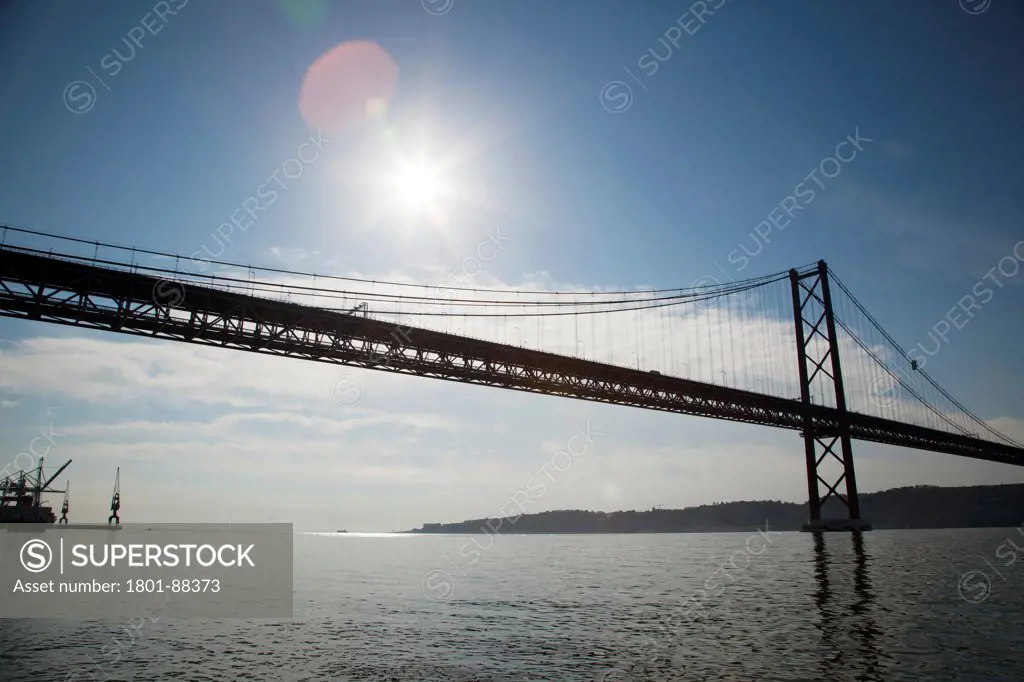 25 de Abril Bridge, Lisbon, Portugal. Architect Steinman, Boynton, Gronquist & Birdsall, 1966. Early morning view with the sun shining through.