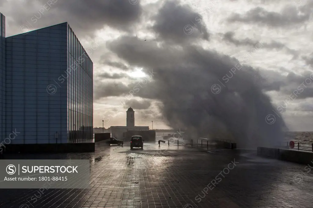 Turner Contemporary Gallery, Margate, United Kingdom. Architect David Chipperfield Architects Ltd, 2011. A wave crashing into the sea wall in front of the Turner gallery.