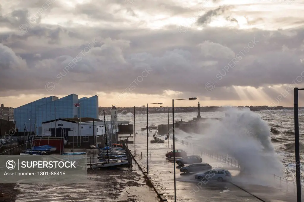 Turner Contemporary Gallery, Margate, United Kingdom. Architect David Chipperfield Architects Ltd, 2011. A wave crashing into the sea wall in front of the Turner gallery.