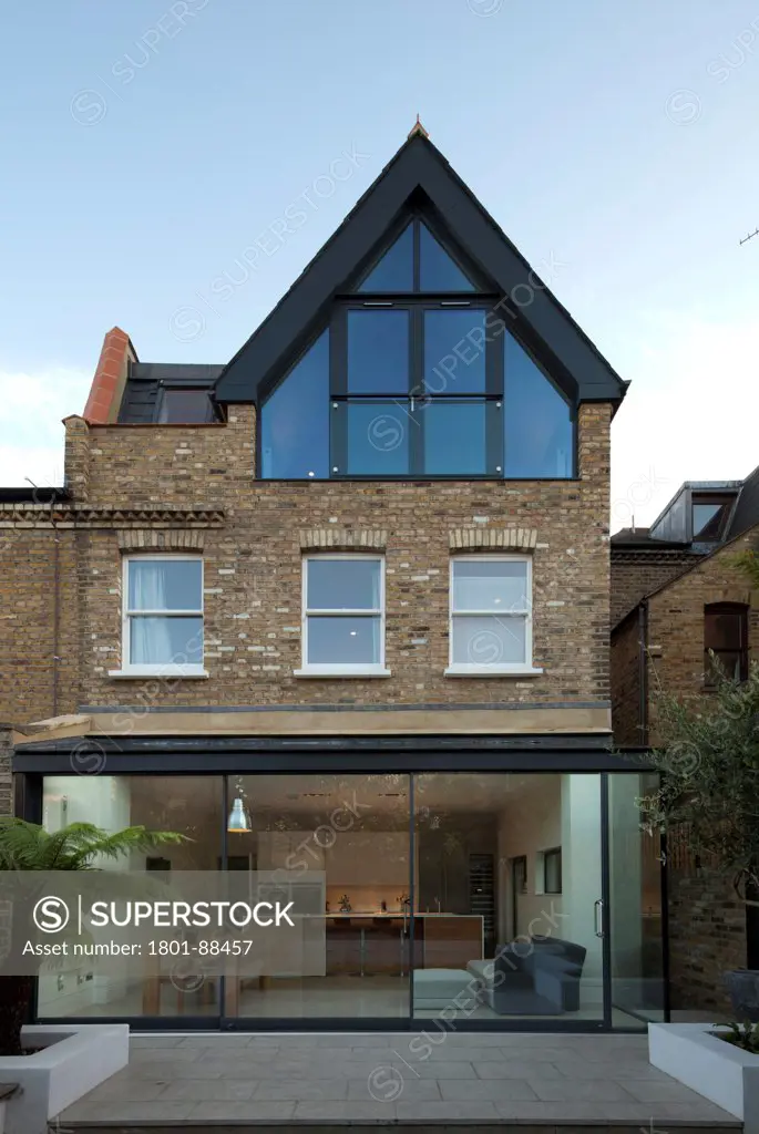 Dents Road, London, United Kingdom. Architect h2 Architecture, 2012. Wide view from garden looking back at kitchen conversion.