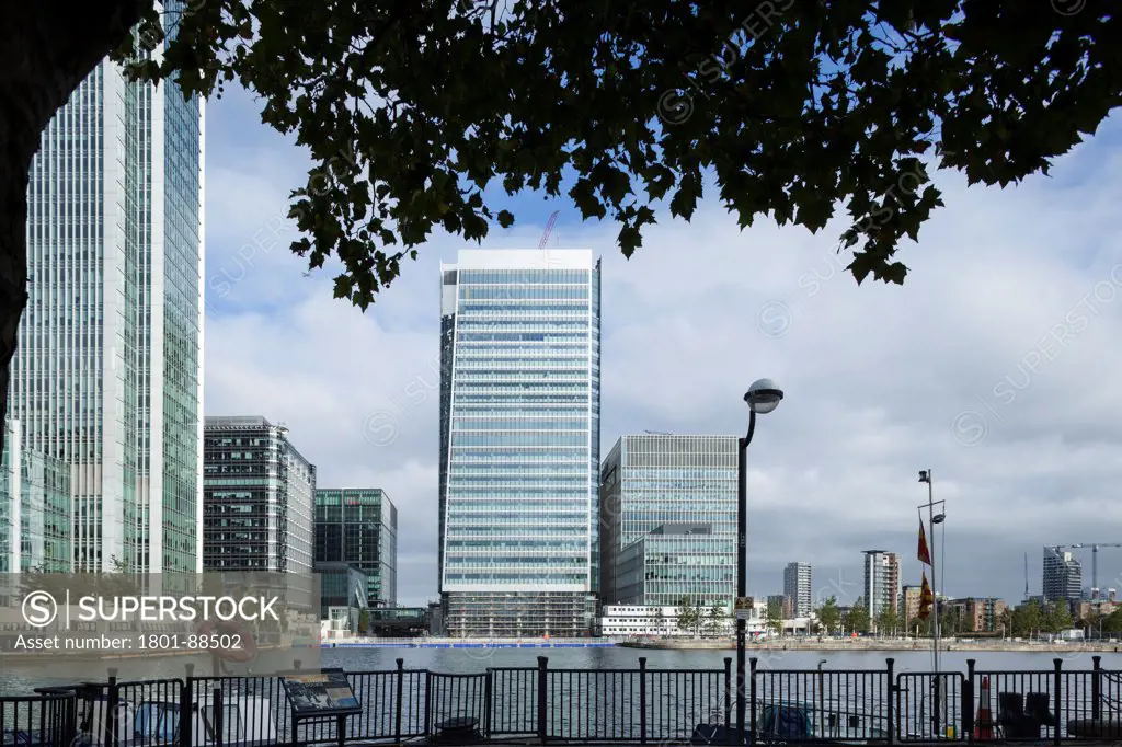 25 Churchill Place, London, United Kingdom. Architect Kohn Pederson Fox, 2014. Wide view across dock framed by tree.