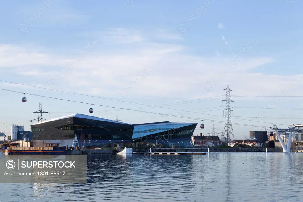 The Crystal, London, United Kingdom. Architect Wilkinson Eyre, 2013. Wide view from across dock with cable cars.