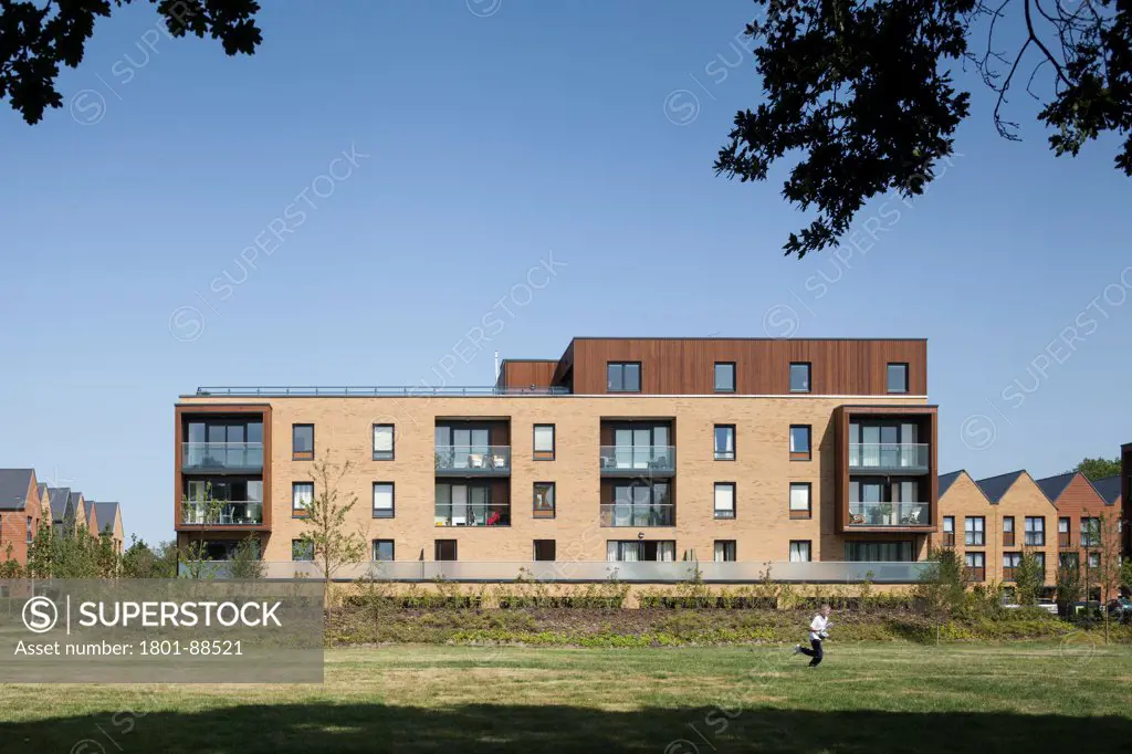 Kidbrooke Village, London, United Kingdom. Architect lifschutz davidson, 2013. Front elevation of housing block framed by tree.
