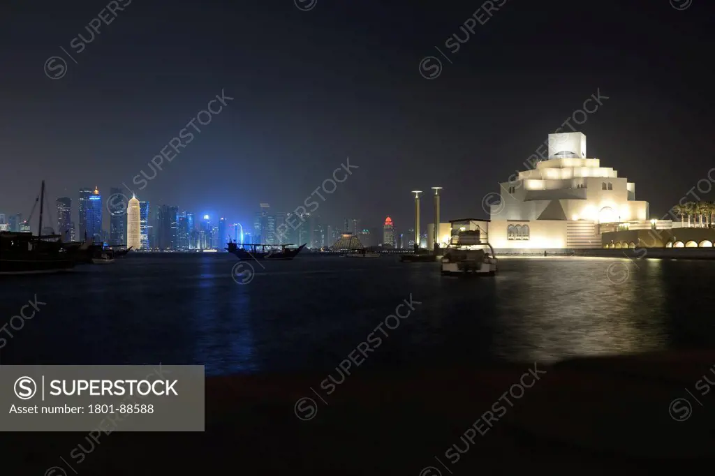Burj Qatar, Doha Tower, Doha, Qatar. Architect Ateliers Jean Nouvel, 2012. Night skyline of Doha's corniche showing Burj Qatar in relation with the volumes of the Islamic Art Museum by Ieoh Ming Pei.