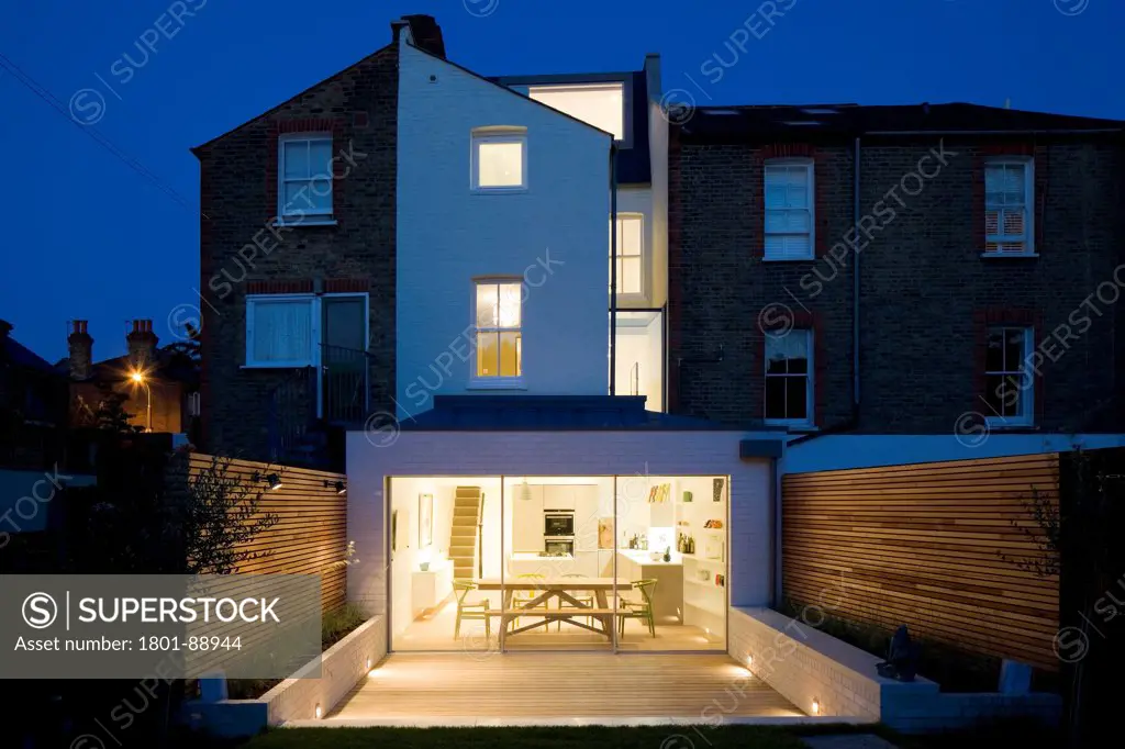 Fulham House, London, United Kingdom. Architect Studio Carver, 2013. Dusk view of rear exterior of house.