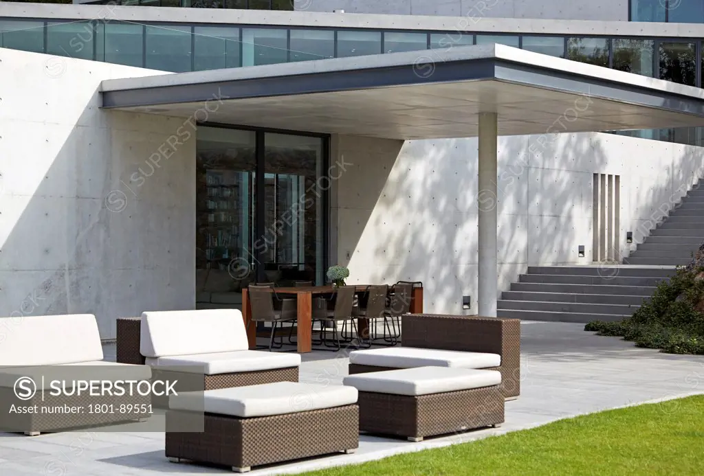 Casa Monterrey, Monterrey, Mexico. Architect: Tadao Ando, 2013. Exterior view showing sun loungers and dining table.