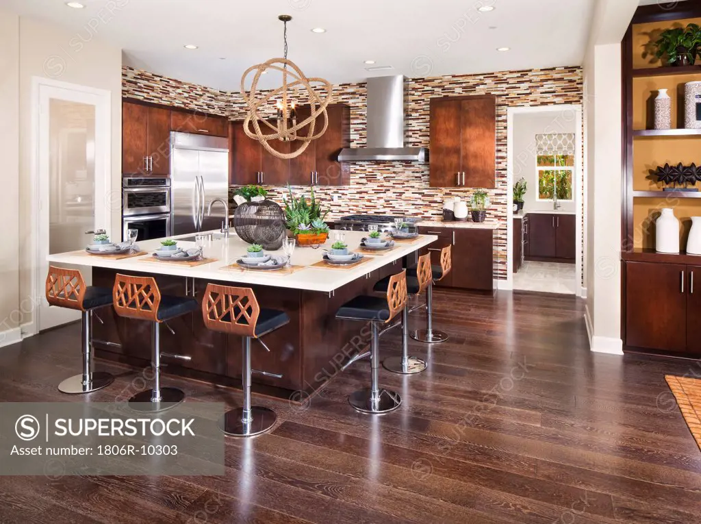 Stools arranged at kitchen island in modern home, Brea, California, USA. 03/15/2013