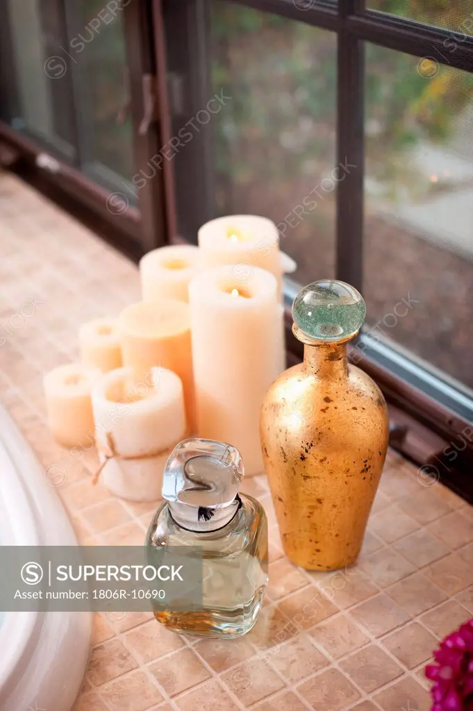 Close-up of candles and jars on counter against closed window at home. 01/22/2013