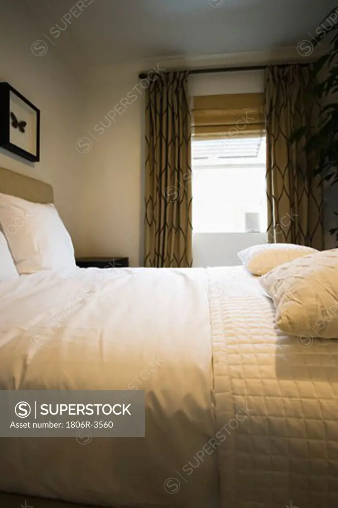 Clean White Bed with Quilt and Pillows