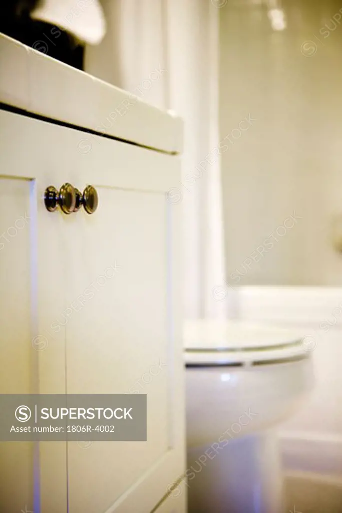 White Cupboard with Chrome Knobs in Traditional Bathroom