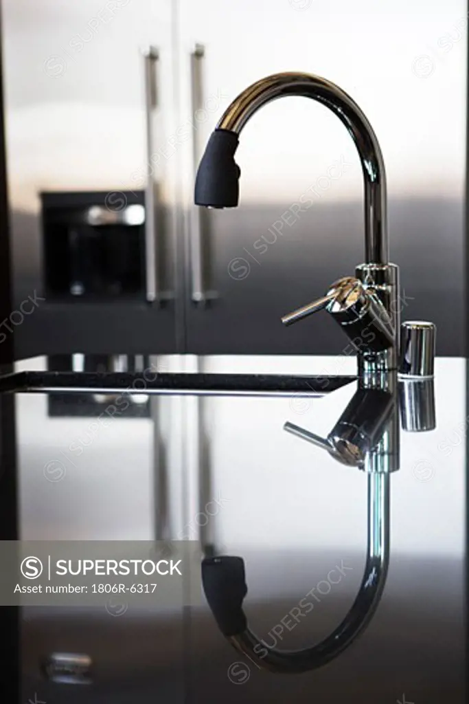 Modern water faucet with reflection.