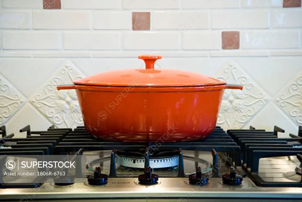 Orange cooking pot on stove top.