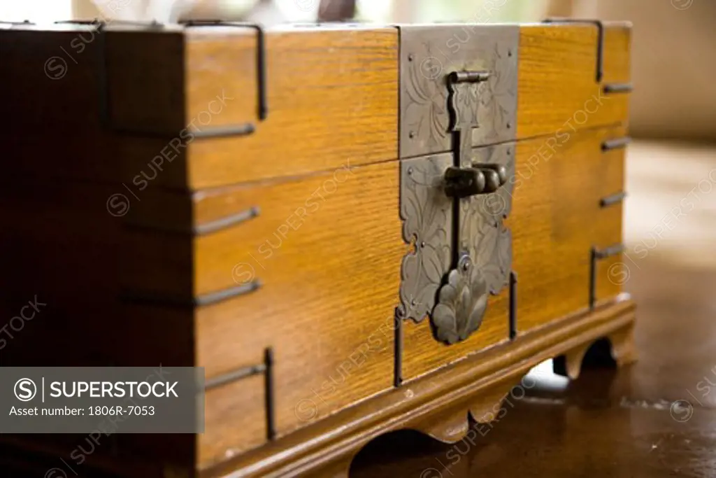 Detail of decorative metal latch on wooden chest.