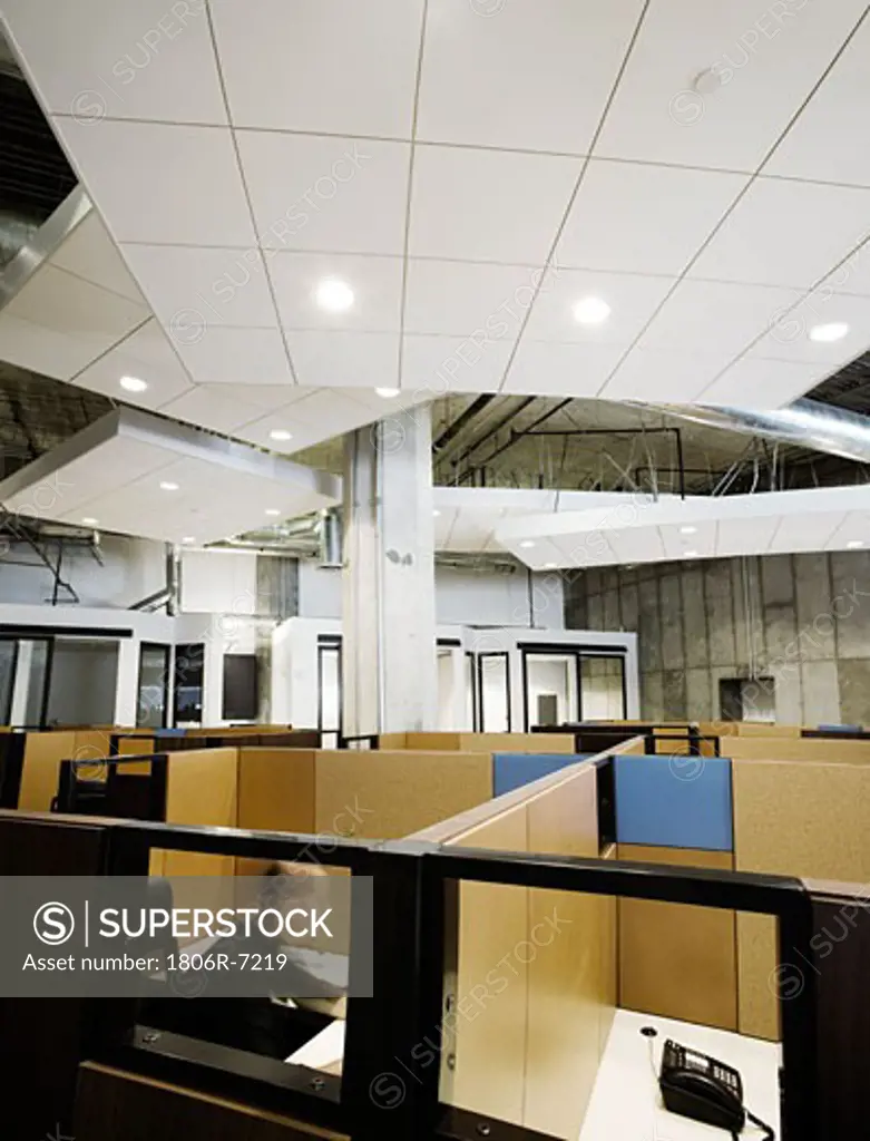 Interior of modern office space with cubicles and man working