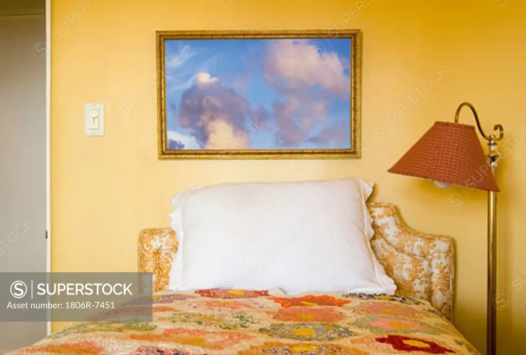 Decorative full bed with a floor lamp in yellow room