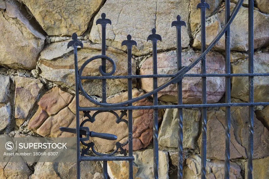 Cast iron gate open against rockwall
