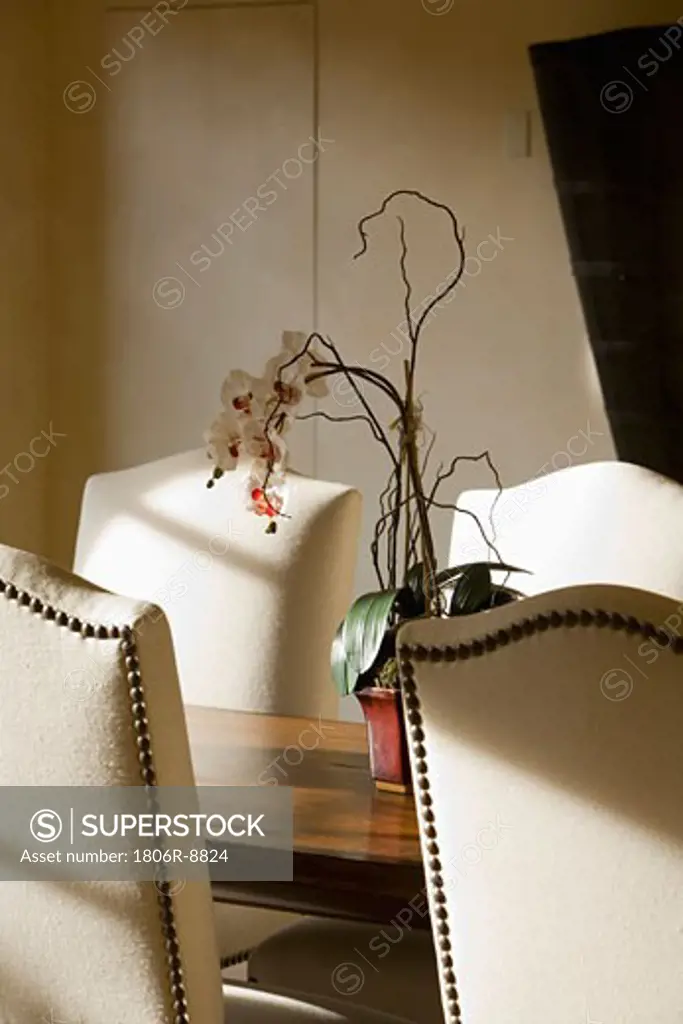High back chairs at dining table with floral centerpiece