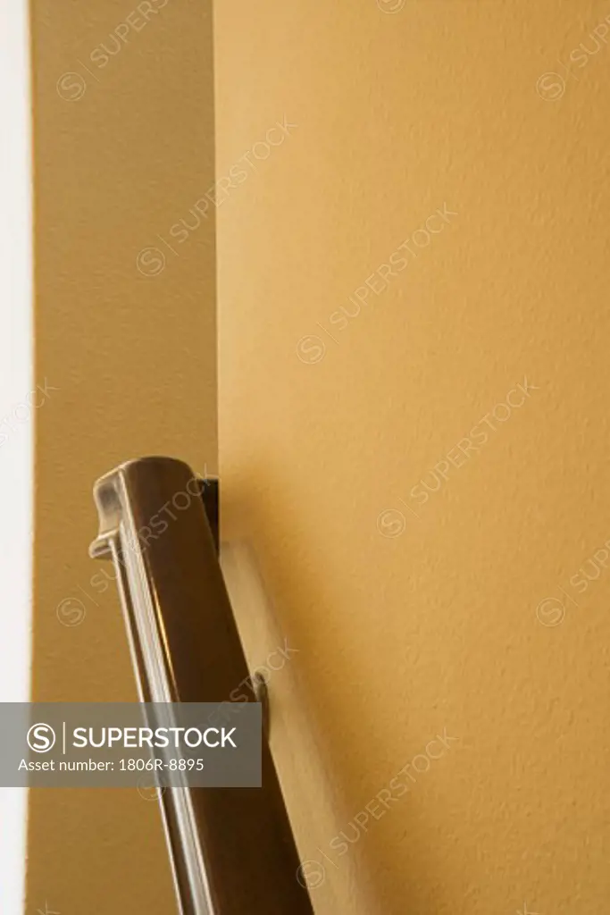 Wooden hand rail on yellow wall