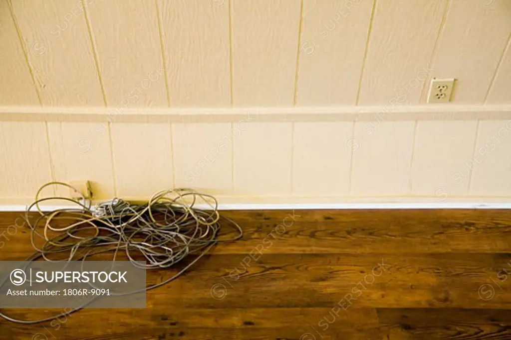 Tangle phone cords on a pile on hardwood floor
