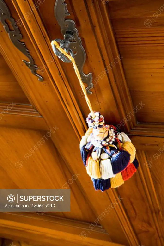 Large colorful tassel hanging on handle of cabinet