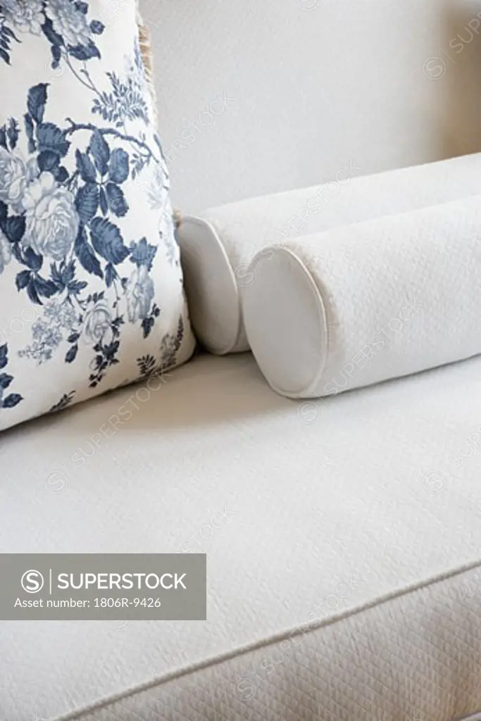 Detail white sofa with floral patterned throw pillow