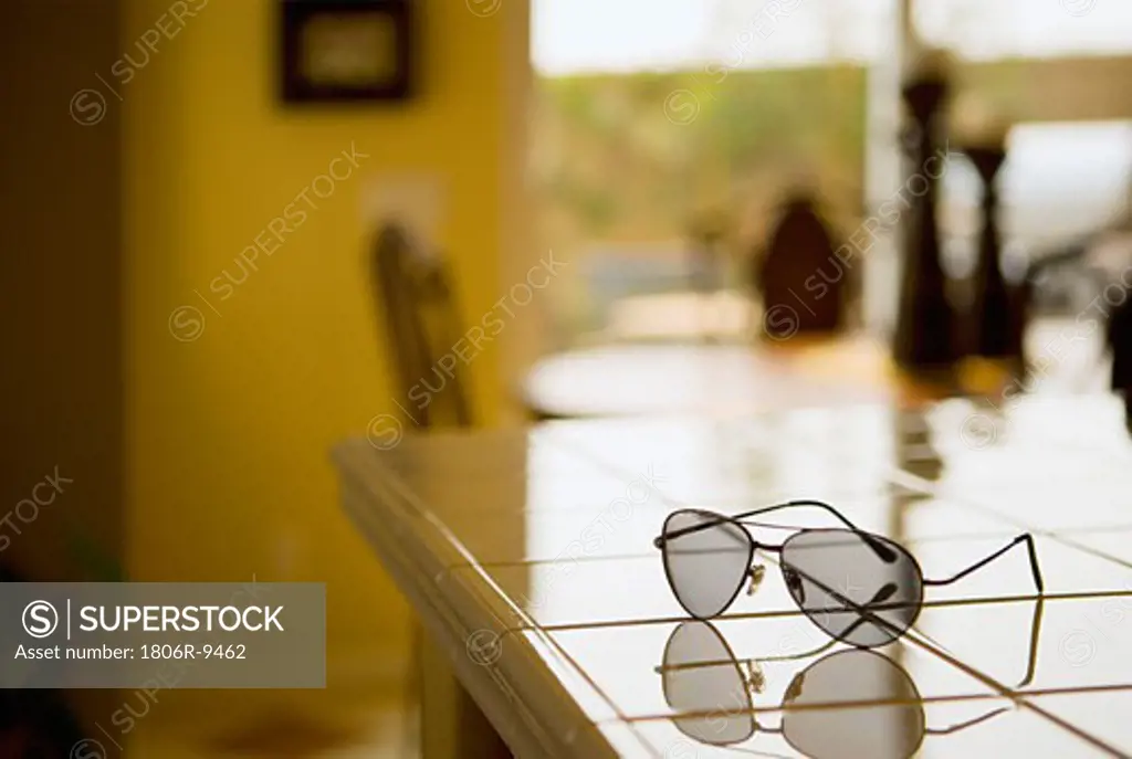 Pair of aviator sunglasses on tile kitchen counter