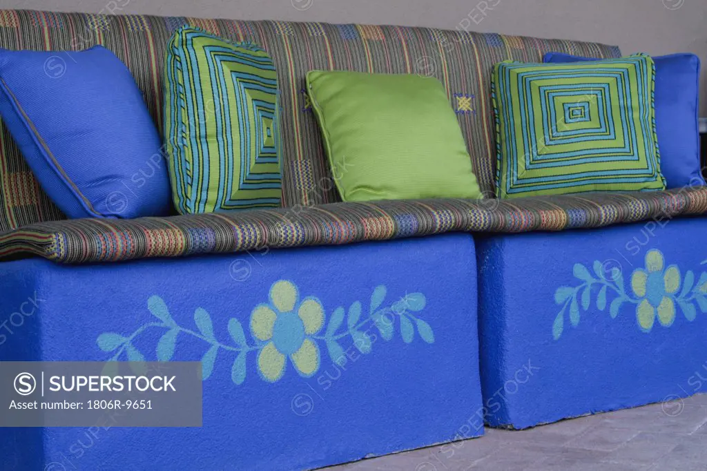 Bright blue bench with decorative throw pillows and cushions