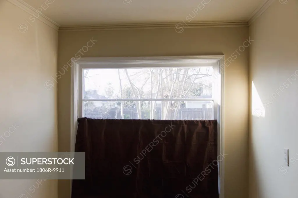 Dark burgundy curtain in front of window