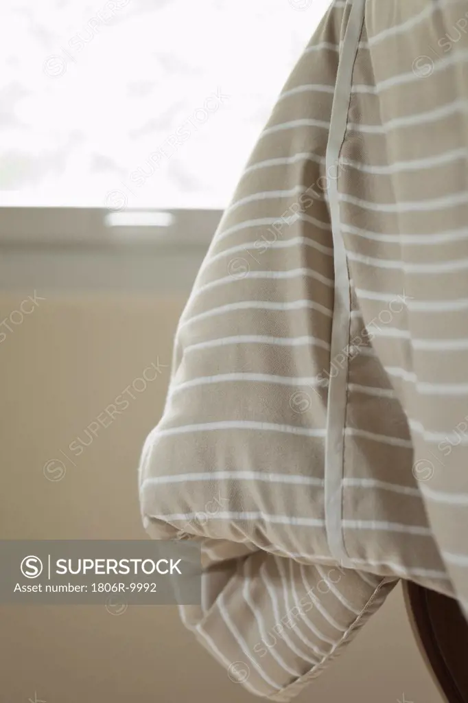 Striped blanket hanging off bed