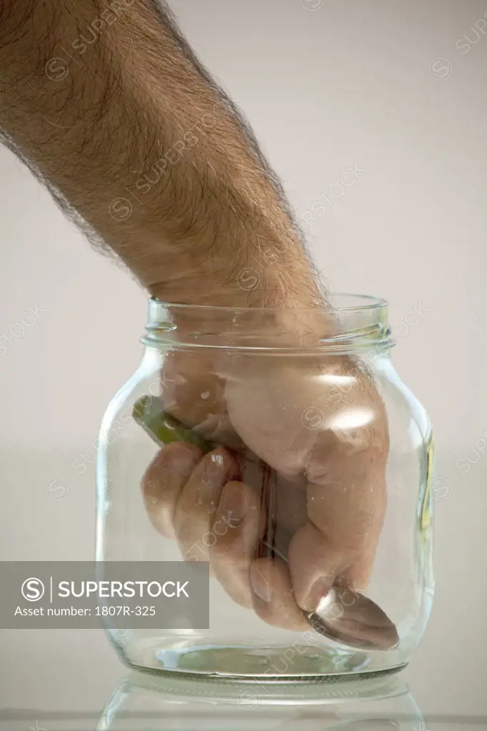 Hand in jar holding spoon
