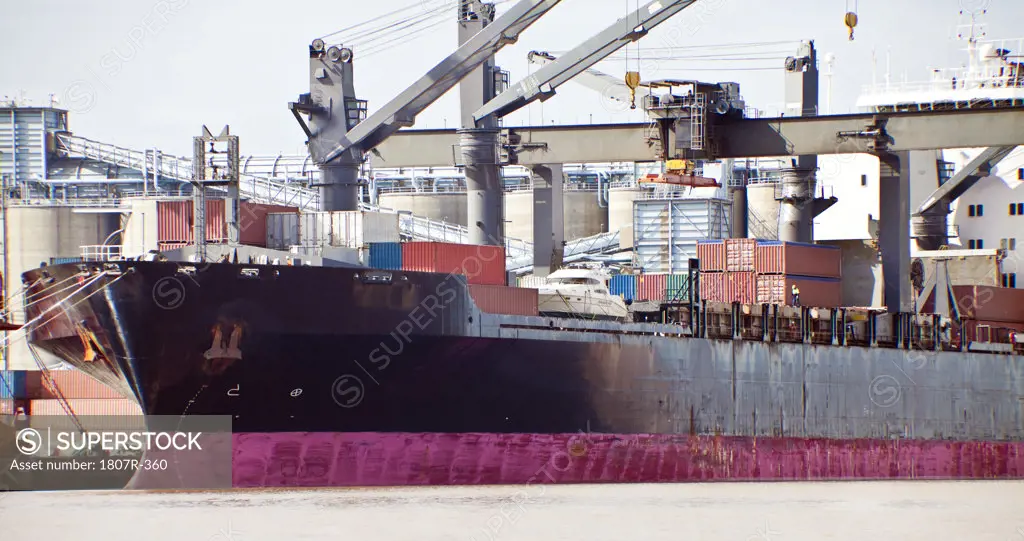 Cargo ship being loaded at industrial port