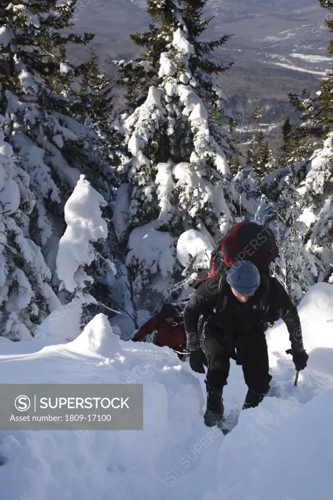 A winter hiker ascending the Carter - Moriah Trail on his way to Mount Moriah during the winter months in the White Mountains, New Hampshire USA