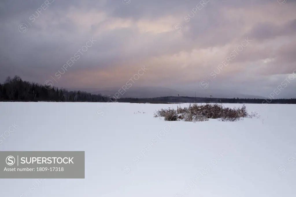 Pondicherry Wildlife Refuge - Sunrise from Cherry Pond during stormy weather (snow storm) in Jefferson, New Hampshire USA during the winter months