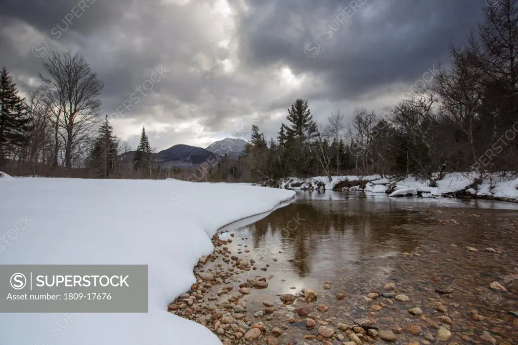 Swift River during the winter months in Albany, New Hampshire USA. This river travels along side of the Kancamagus Scenic Byway, which is one of New England's scenic byways. Mount Passaconaway is off in the distance
