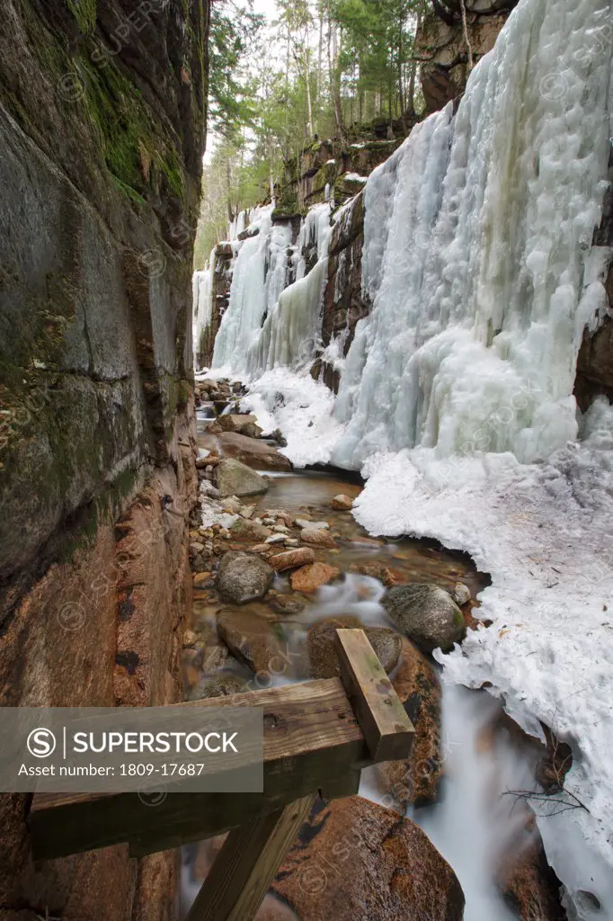 Franconia Notch State Park - Flume Gorge during the spring months in Lincoln, New Hampshire USA. The wooden support in the foreground is part of a wooden boardwalk that travels up the gorge. It is removed during the winter season.