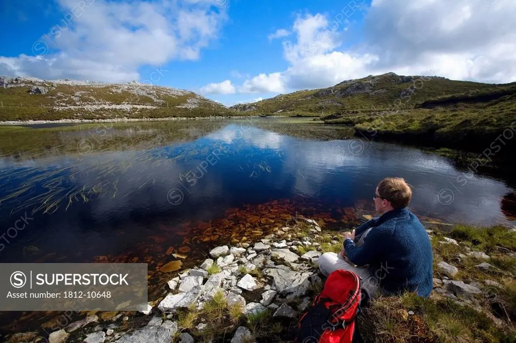 Aghla Mountain, Co Donegal, Ireland, Man resting beside a mountain pool