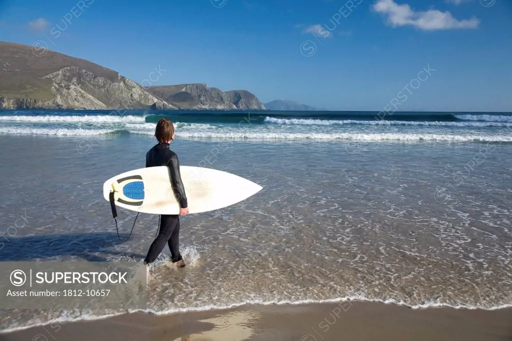 Achill Island, Co Mayo, Ireland, Surfer walking along Trawmore beach