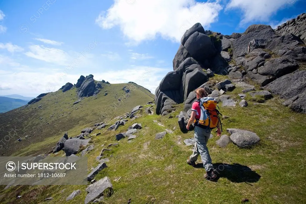 Mourne Mountains, Co Down, Northern Ireland, Hiker passing the North Tor of Slieve Bearnagh