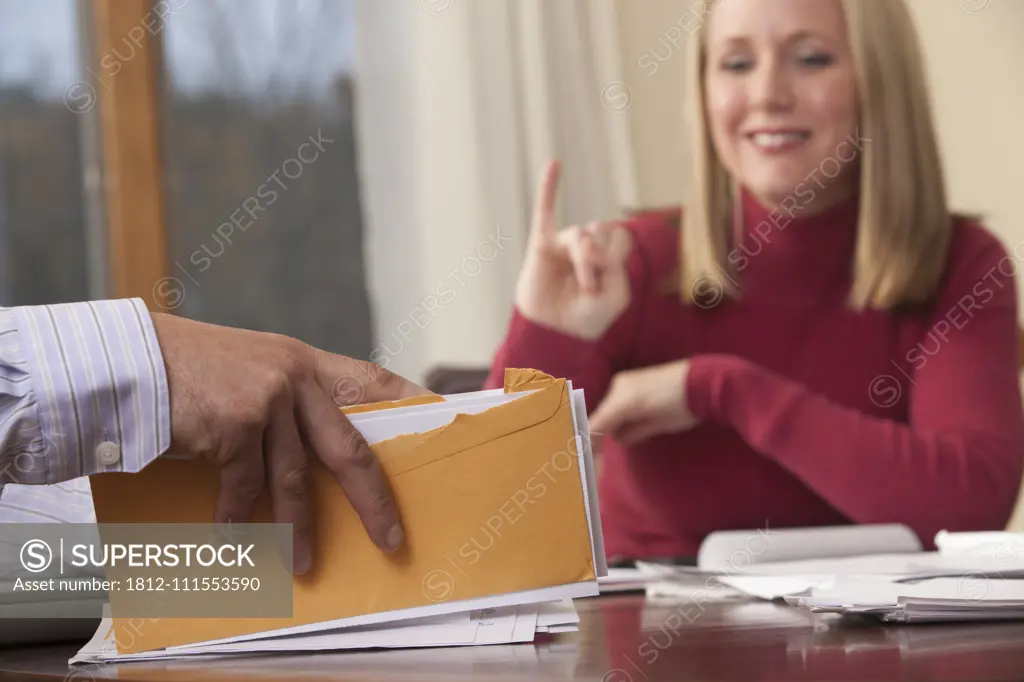 Woman signing the word 'Insurance' in American Sign Language while communicating with a man
