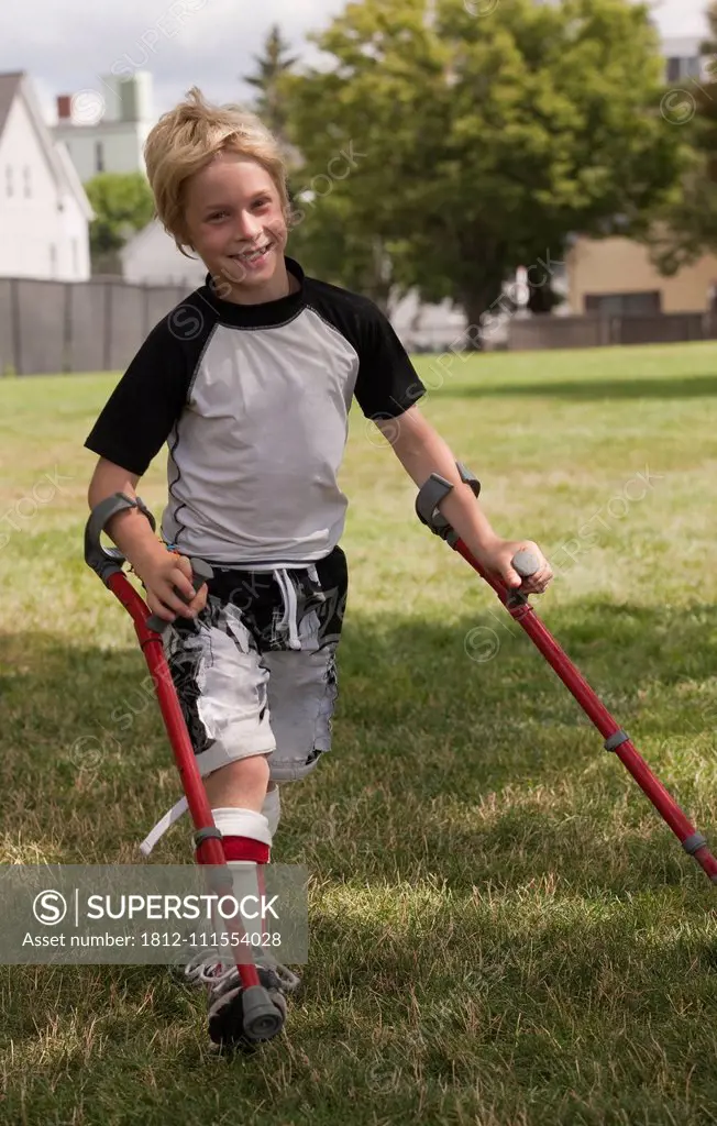 Boy with cerebral palsy walking with the support of crutches
