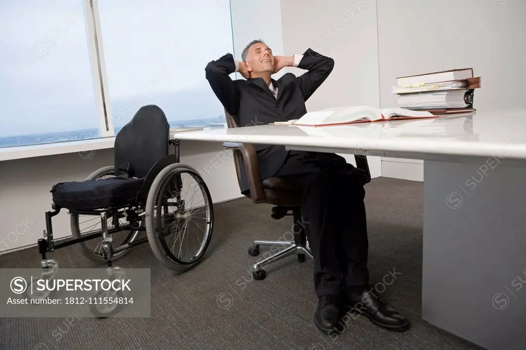 Businessman with a wheelchair relaxing in office