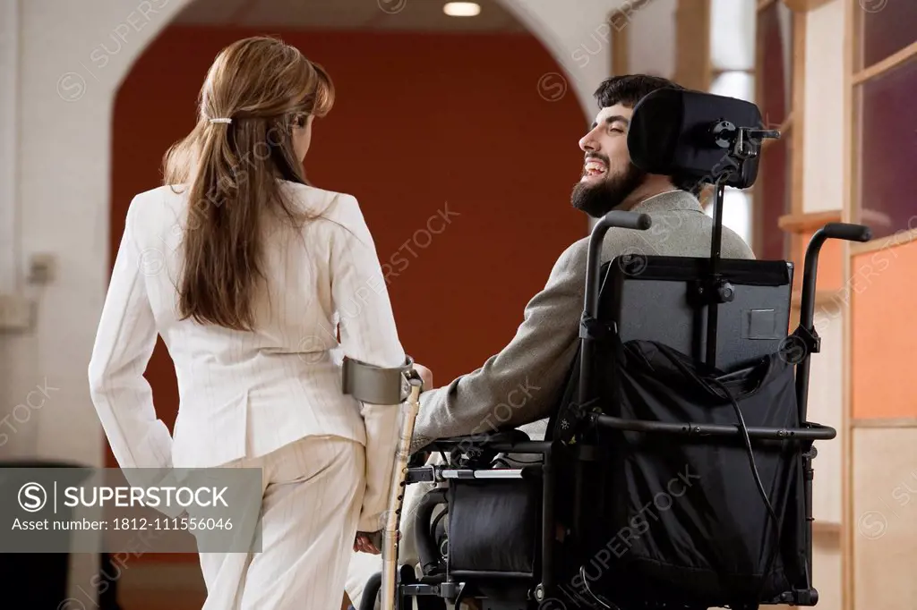 Man with Cerebral Palsy and woman with cane conversing.