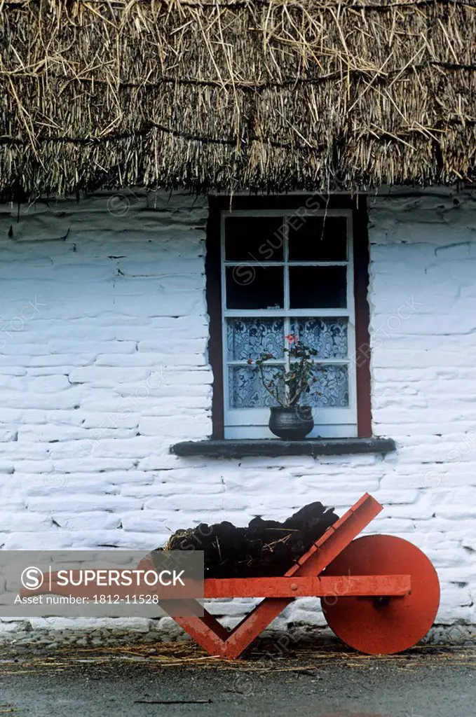 Wheelbarrow In Front Of A Window Of A Cottage, Bunratty Folk Park, Bunratty, County Clare, Republic Of Ireland