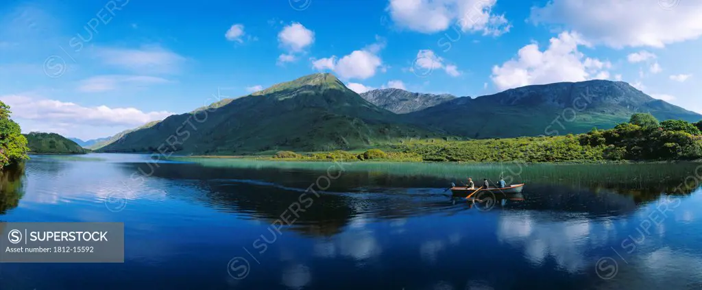 Three People On A Boat In The Lake, Kylemore Lake, County Galway, Republic Of Ireland