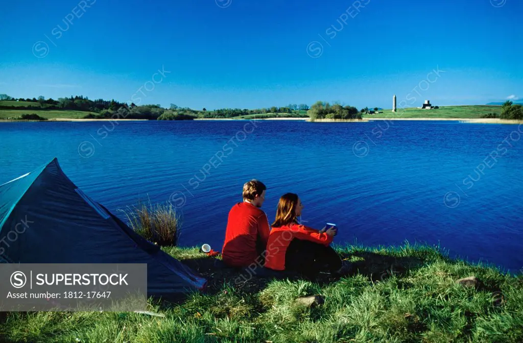 Camping Couple Outside Tent Enjoying Water View