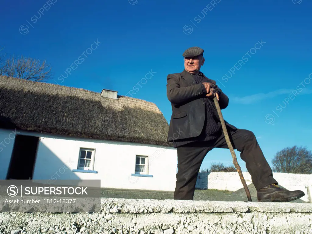 Co Galway,Ireland;Farmer Stands Outside His Thatched Cottage