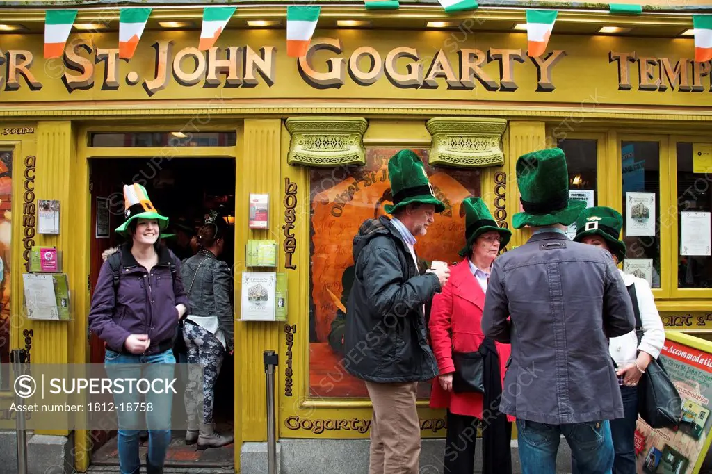 Dublin, Ireland; People Gathered Outside A Store Wearing Big Green Hats For Saint Patrick's Day